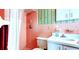 Striking bathroom featuring colorful wallpaper, sink, and updated shower at 1919 Harpoon Dr, Holiday, FL 34690