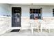 Cozy front porch with seating area and stone brick detailing on house facade at 1919 Harpoon Dr, Holiday, FL 34690