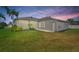 Well-maintained backyard featuring lush green grass, screened patio and mature landscaping at 22118 Yachtclub Ter, Land O Lakes, FL 34639