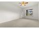 Bright, carpeted bedroom with a ceiling fan and a large window with a view at 22118 Yachtclub Ter, Land O Lakes, FL 34639