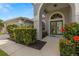 Close up of a home's entrance with beautiful green doors and colorful landscaped plants at 22118 Yachtclub Ter, Land O Lakes, FL 34639