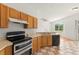Bright kitchen with wood cabinets, modern appliances, tile flooring, and a view of the greenery outside at 22118 Yachtclub Ter, Land O Lakes, FL 34639