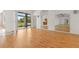 Bright and airy living room features wood floors, a large glass sliding door, and access to other rooms at 22118 Yachtclub Ter, Land O Lakes, FL 34639
