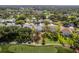 An aerial view shows the home nestled among lush trees and other homes in the community, including views of the golf course at 2327 Morning Glory Trl, Spring Hill, FL 34606