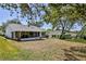 Wide shot of backyard and exterior of home including a screened-in porch and an outside patio set at 2327 Morning Glory Trl, Spring Hill, FL 34606