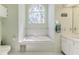 Bathroom featuring a soaking tub with a stained glass window and tiled wall at 2327 Morning Glory Trl, Spring Hill, FL 34606