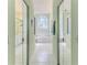 Hallway shot of bathroom with tub, shower, decorative window, and dual mirrored closet doors with mirrored trim at 2327 Morning Glory Trl, Spring Hill, FL 34606