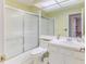 Well-lit bathroom with a shower/tub combo, a white vanity with sink, and neutral tile flooring at 2327 Morning Glory Trl, Spring Hill, FL 34606