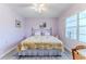 Cozy bedroom featuring a ceiling fan, large window, and calming lavender walls at 2327 Morning Glory Trl, Spring Hill, FL 34606