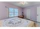 Cozy bedroom featuring hardwood floors, a large window for natural light, and a comfortable bed with decorative pillows at 2327 Morning Glory Trl, Spring Hill, FL 34606