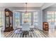 Dining area features a glass table, chairs, ample natural light, and an antique grandfather clock at 2327 Morning Glory Trl, Spring Hill, FL 34606