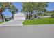 Inviting home with lush green lawn, a driveway leading to a two-car garage, and mature trees at 2327 Morning Glory Trl, Spring Hill, FL 34606