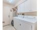 Functional laundry room equipped with a washer, dryer, storage cabinets, and a sink at 2327 Morning Glory Trl, Spring Hill, FL 34606