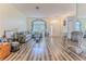 Bright living room featuring wood-look flooring and large window overlooking the front yard at 2327 Morning Glory Trl, Spring Hill, FL 34606