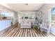 Inviting living room area featuring a cozy couch, wood floors, a bright window and an open floor plan at 2327 Morning Glory Trl, Spring Hill, FL 34606