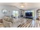 Living room features hardwood floors, a fireplace, and large windows providing natural light and beautiful views of the surrounding landscape at 2327 Morning Glory Trl, Spring Hill, FL 34606