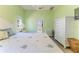 Cozy main bedroom with a white furniture set, blue accents, light green walls, and doorway that leads into the bathroom at 2327 Morning Glory Trl, Spring Hill, FL 34606
