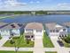 Beautiful aerial view of homes near a lake, featuring manicured lawns and scenic water views on a sunny day at 3208 Living Coral Dr, Odessa, FL 33556