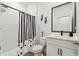 Clean bathroom featuring a shower with black and white shower curtain, toilet and sink at 3208 Living Coral Dr, Odessa, FL 33556