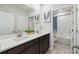 Well-lit bathroom with double sinks, dark cabinets and a shower over bath, offering a blend of style and functionality at 3208 Living Coral Dr, Odessa, FL 33556