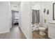 Hallway view of a half bathroom with a black and white shower curtain at 3208 Living Coral Dr, Odessa, FL 33556