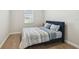 Cozy bedroom with a blue bed frame, wood floor, and a bright window at 3208 Living Coral Dr, Odessa, FL 33556