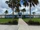 Community clubhouse exterior showcasing manicured lawns, blue siding, and a welcoming entrance walkway at 3208 Living Coral Dr, Odessa, FL 33556