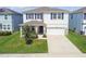 Beautiful two-story home featuring a well-manicured lawn, blue shutters, stone accents, and a two-car garage at 3208 Living Coral Dr, Odessa, FL 33556