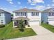 Charming two-story home with manicured lawn, blue shutters, stone accents, and a two-car garage at 3208 Living Coral Dr, Odessa, FL 33556