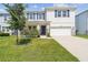 Two-story home with blue shutters, a well-manicured lawn, and a stone-accented facade at 3208 Living Coral Dr, Odessa, FL 33556