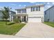 Charming two-story home with a well-manicured lawn and a stone-accented facade at 3208 Living Coral Dr, Odessa, FL 33556