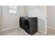 Functional laundry room with modern front-load washer and dryer, tile flooring, and a convenient shelving unit at 3208 Living Coral Dr, Odessa, FL 33556