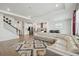 Open-concept living room with a large sofa, modern rug, and an adjacent staircase at 3208 Living Coral Dr, Odessa, FL 33556