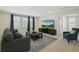 Comfortable living room features a TV, neutral color palette, and natural light from large windows at 3208 Living Coral Dr, Odessa, FL 33556
