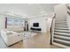 Spacious living room with tray ceiling, lots of natural light, and modern decor adjacent to the staircase at 3208 Living Coral Dr, Odessa, FL 33556