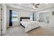 Spacious main bedroom featuring a tray ceiling, ceiling fan, and view of the lake at 3208 Living Coral Dr, Odessa, FL 33556