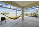 Enclosed patio with a hammock, offering a relaxing view of the serene lake and lush scenery at 3208 Living Coral Dr, Odessa, FL 33556