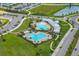 Aerial view of the community pool area with multiple pools, seating, and lush landscaping at 3208 Living Coral Dr, Odessa, FL 33556