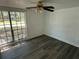 Bedroom showcasing dark ceiling fan, laminate flooring, and a large window for ample natural light at 3617 Rockaway Dr, Holiday, FL 34691