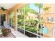 Relaxing sunroom with outdoor furniture overlooking the manicured backyard garden and neighboring houses at 3655 Square West Ln # 9, Sarasota, FL 34238