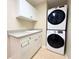 Functional laundry room with a sink, ample cabinet space, and a stacked washer and dryer unit at 3655 Square West Ln # 9, Sarasota, FL 34238