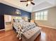 Comfortable main bedroom with a blue accent wall, hardwood floors and shuttered windows at 3655 Square West Ln # 9, Sarasota, FL 34238