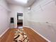 Spacious walk-in closet with hardwood floors, custom shelving, and an open doorway into the main bedroom at 3655 Square West Ln # 9, Sarasota, FL 34238