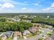 An aerial view of a beige single-Gathering home featuring a manicured lawn, an attached two-car garage, and a shingled roof at 4080 Gevalia Dr, Brooksville, FL 34604