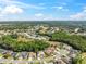 Expansive aerial view of a residential community surrounded by lush greenery under a bright, partly cloudy sky at 4080 Gevalia Dr, Brooksville, FL 34604