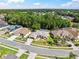 An aerial view of a beige single-Gathering home featuring a manicured lawn, an attached two-car garage, and a shingled roof at 4080 Gevalia Dr, Brooksville, FL 34604