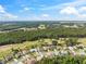 Scenic aerial shot of a residential area bordered by dense forest, featuring well-spaced homes and green spaces at 4080 Gevalia Dr, Brooksville, FL 34604