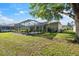 Expansive backyard with screened-in pool, mature trees, and beautiful landscaping, perfect for outdoor activities at 4080 Gevalia Dr, Brooksville, FL 34604
