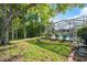 Spacious backyard featuring a screened-in pool enclosure, trees, and well-manicured lawn at 4080 Gevalia Dr, Brooksville, FL 34604