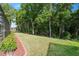 Picturesque backyard with mature trees, a well-maintained lawn, and a hint of a screened-in enclosure at 4080 Gevalia Dr, Brooksville, FL 34604